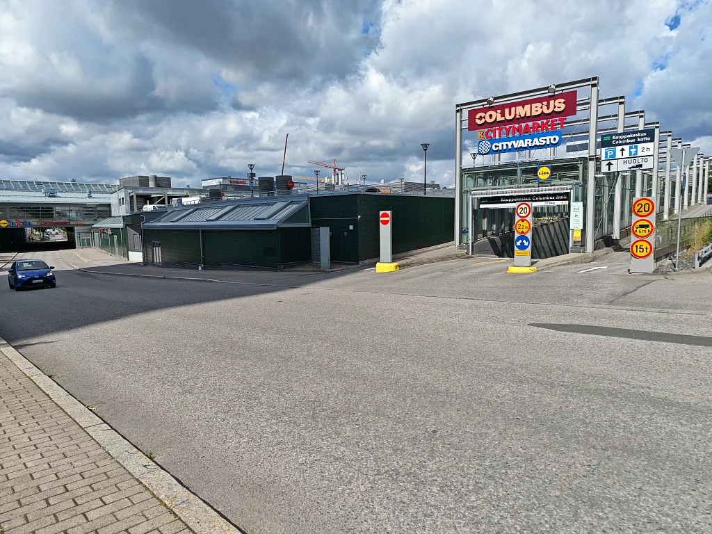 Yläparkkipaikalta: sisäänajo pysäköintiin Columbuksen kyltin alta